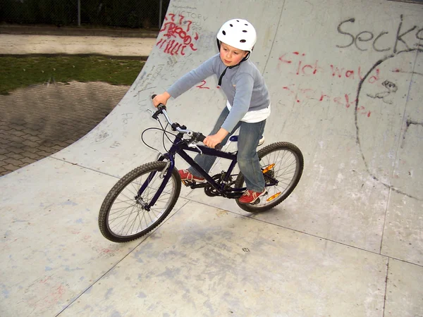 Barn med cykel i halfpipe — Stockfoto