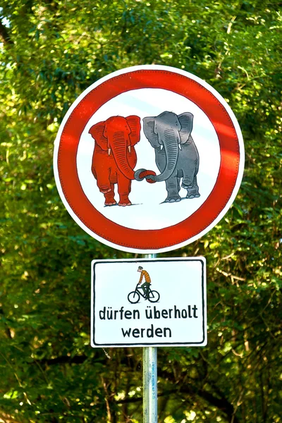 Знак запрещен для слонов в любви и велосипедного обгона позволяют — стоковое фото