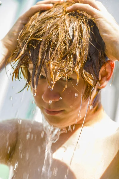 Niño tiene una ducha refrescante en el calor —  Fotos de Stock