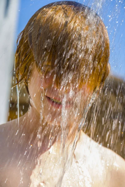 Kind heeft een verfrissende douche in de hitte — Stockfoto