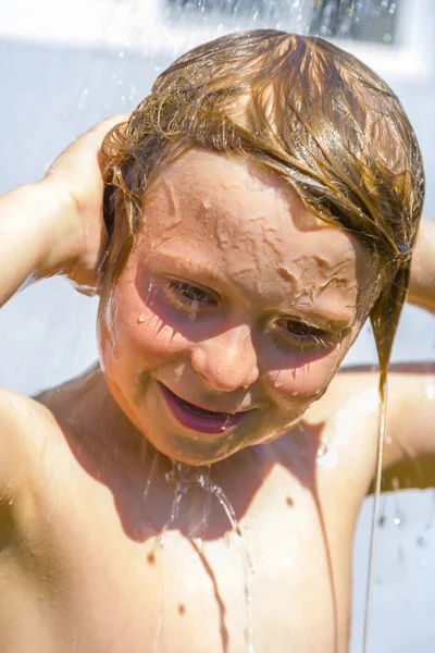 Criança tem um chuveiro refrescante no calor — Fotografia de Stock