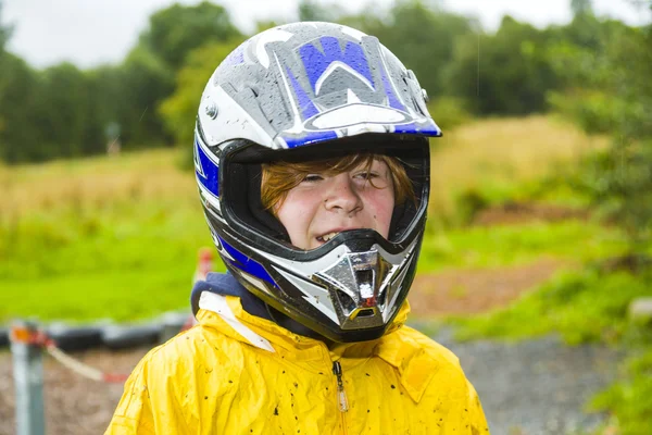 Happy boy with helmet at the kart trail — Stock Photo, Image