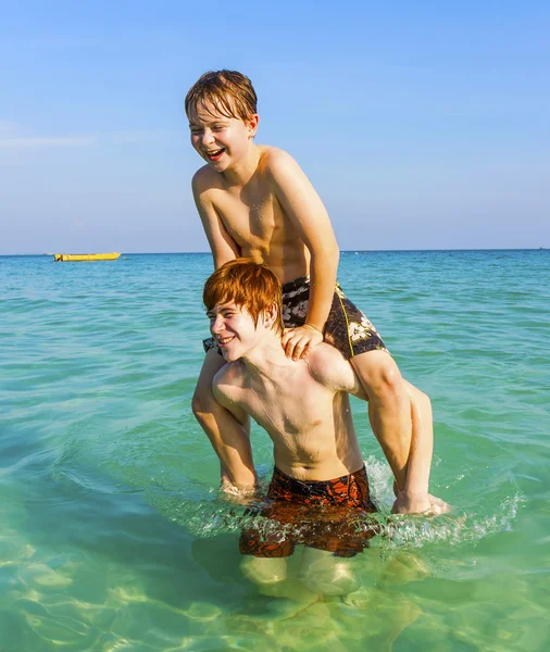 Bratři se těší jasné teplé vody v oceánu a hrát — Stock fotografie