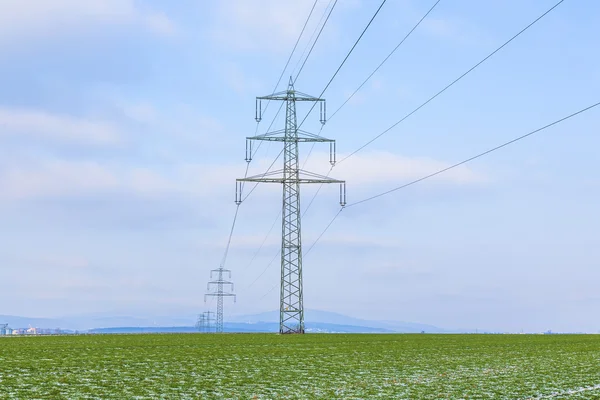 Acres con nieve en invierno con torre de electricidad al atardecer —  Fotos de Stock