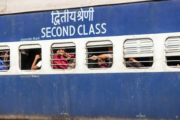 Pasajeros colgando en la ventana de un tren indio en movimiento tra —  Fotos de Stock