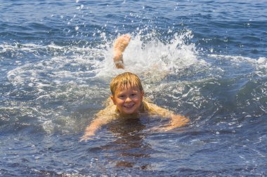 boy has fun playing in the waves