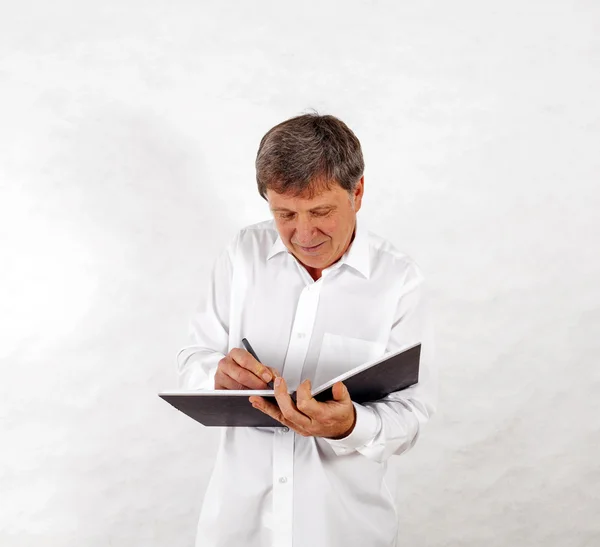 Gelukkig senior man staande gebaren tegen witte achtergrond — Stockfoto