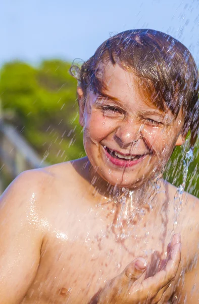 Junge hat eine Dusche am Strand — Stockfoto