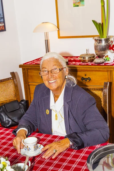 Attraktiv mormor sitter i hennes vardagsrum — Stockfoto
