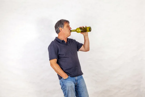 Man drinks alcohol out of a bottle — Stock Photo, Image