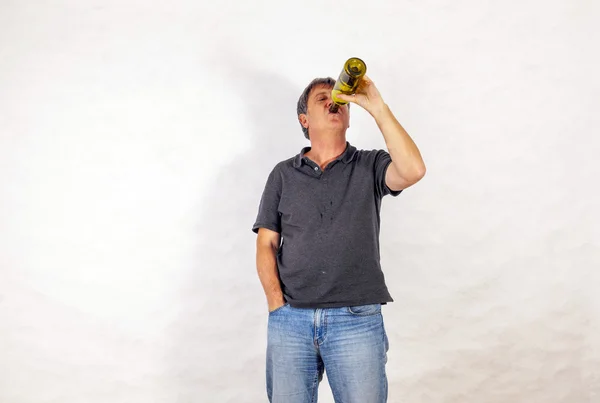 Man drinks alcohol out of a bottle — Stock Photo, Image