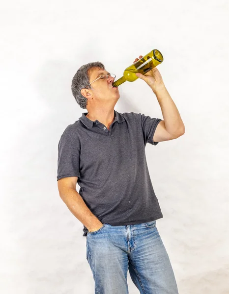 Мужчина пьет алкоголь из бутылки — стоковое фото