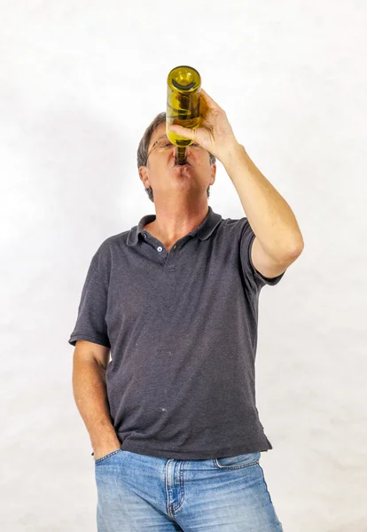 Man drinks alcohol out of a bottle — Stock Photo, Image