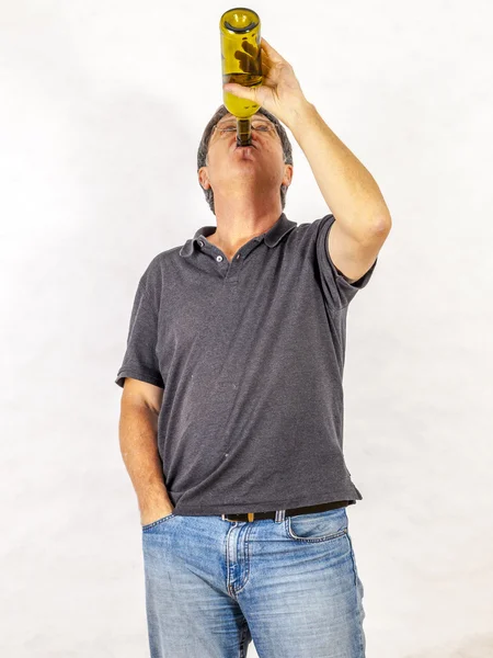 Homme boit de l'alcool dans une bouteille — Photo