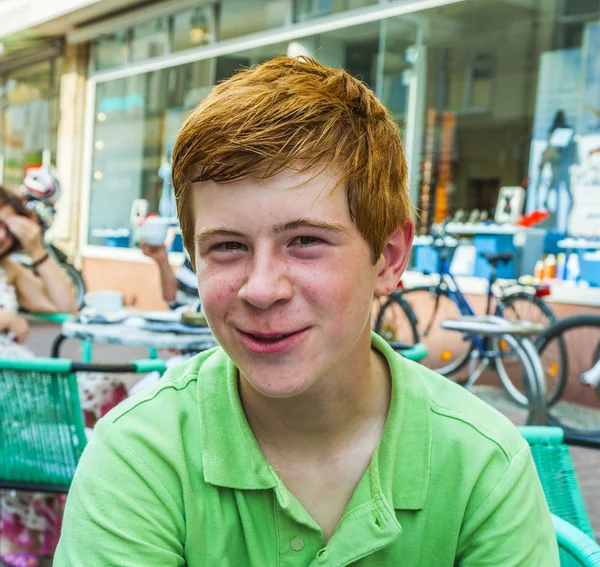 Niño con el pelo rojo se ve feliz y amigable — Foto de Stock