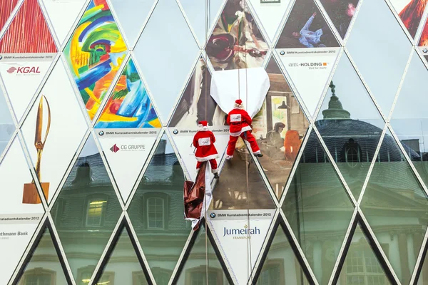 Twee klimmer jurken als santa claus klimmen naar beneden de gevel myzeil — Stockfoto