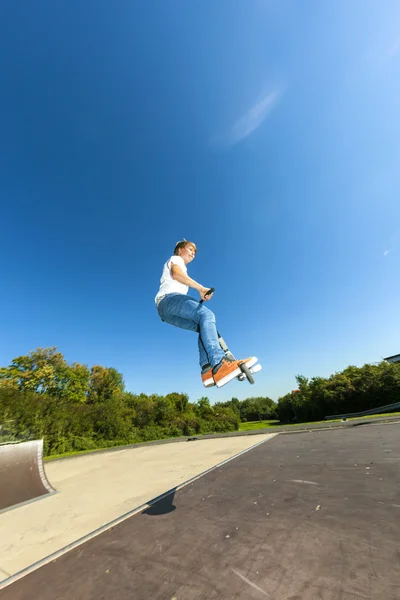 Junge springt mit seinem Roller — Stockfoto