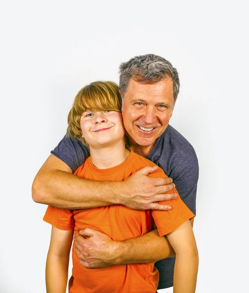 Pai e filho abraçando no estúdio isolado no branco — Fotografia de Stock