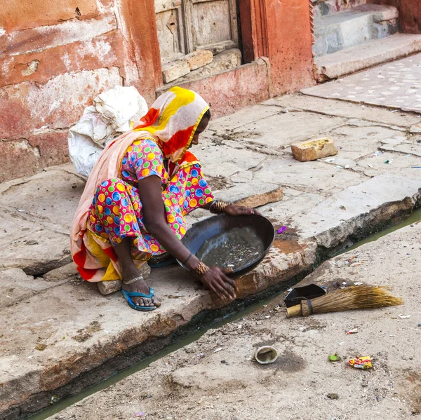 Woman tries to find gold dust in the canalisation — Stock Photo, Image