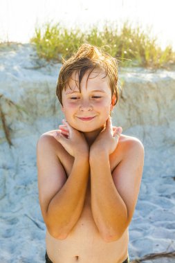 Kumsalda mutlu genç gülümseyen çocuk