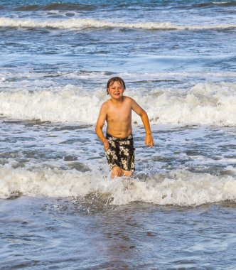 plajda su ile çalışan genç çocuk