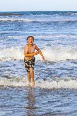 plajda su ile çalışan genç çocuk