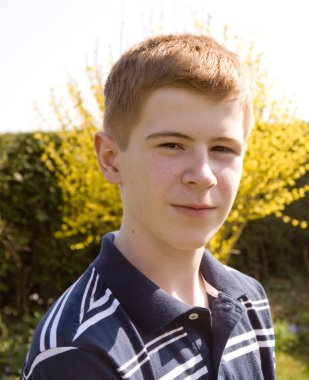 Genç kızıl saçlı çocuk kendinden emin ve mutlu görünüyor.