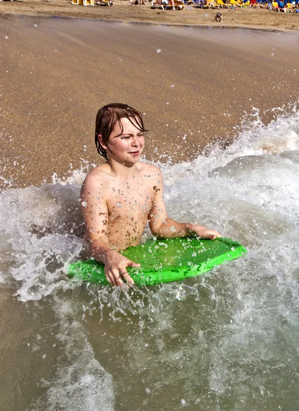 Niño con tabla de surf en el océano — Foto de Stock