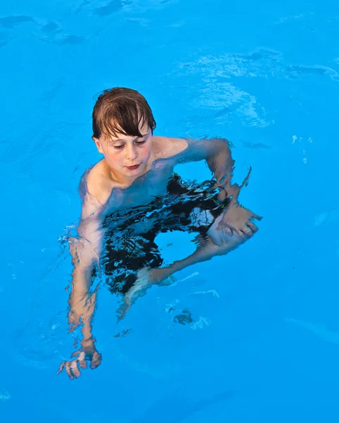 プールで泳いでいる少年は楽しい — ストック写真