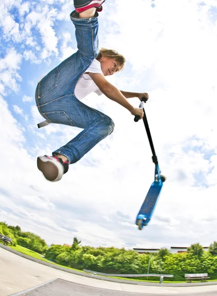 Ragazzo con scooter sta andando in volo — Foto Stock