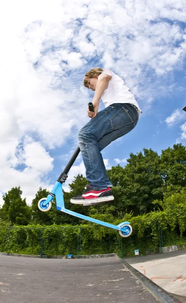 Boy with scooter is going airborne — Zdjęcie stockowe