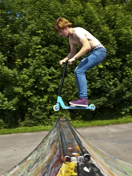 年轻男孩会空降与滑板车 — 图库照片
