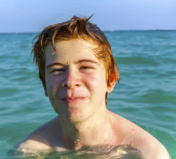 Jongen met rood haar is genieten van het duidelijk warm water op de beauti — Stockfoto