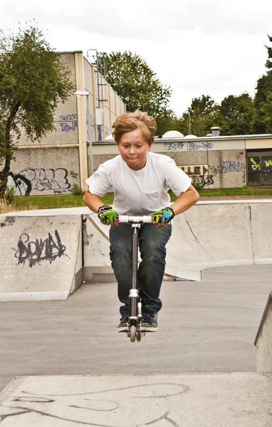 Carino ragazzo scooting con la sua scooter — Foto Stock