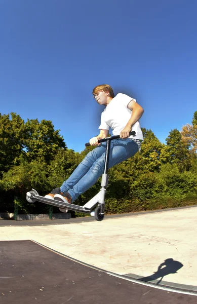 Garçon sautant avec son scooter — Photo