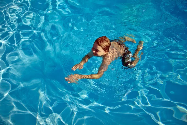 Criança nada na piscina — Fotografia de Stock