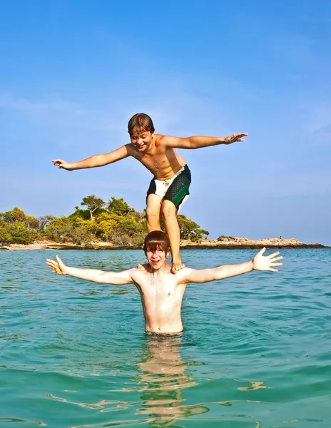 Broers zijn samenspelen in een prachtige zee met crystal cl — Stockfoto