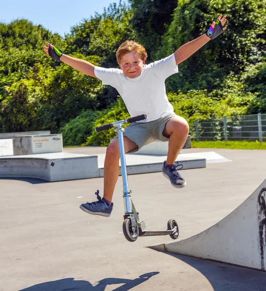 Chico salta con su scooter —  Fotos de Stock