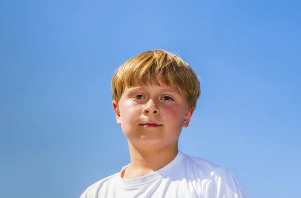 Glada leende pojken njuter av livet under blå himmel — Stockfoto