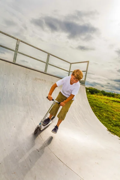 Garçon aime sauter avec son scooter — Photo