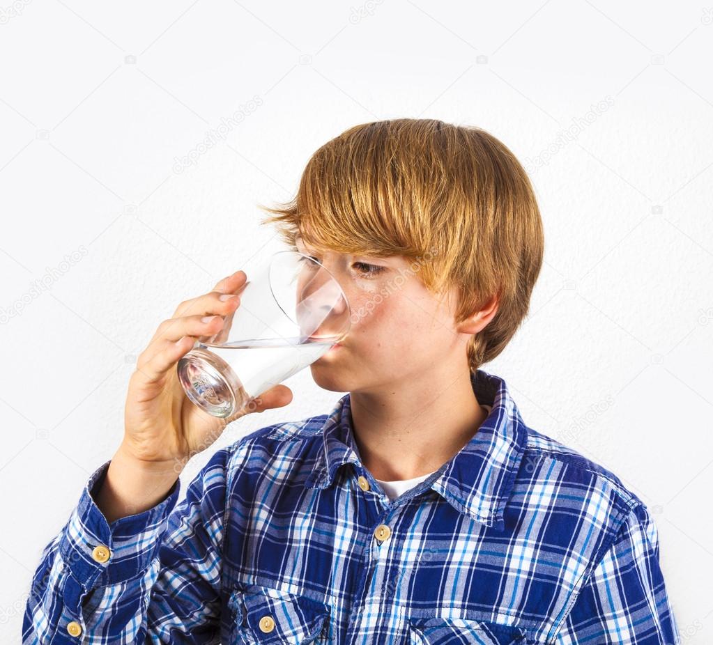 boy drinking water out of a glass