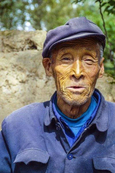 Old farmer in traditional blue working class uniform — Stock Photo, Image