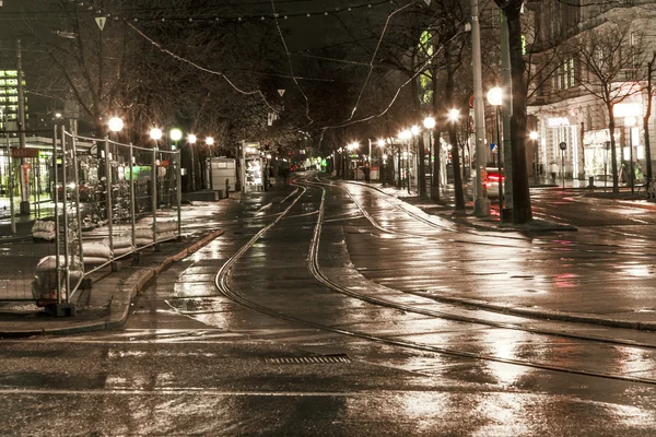 Mokré vozík kolejnice ve světle a ulice jsou odrážející světlo — Stock fotografie