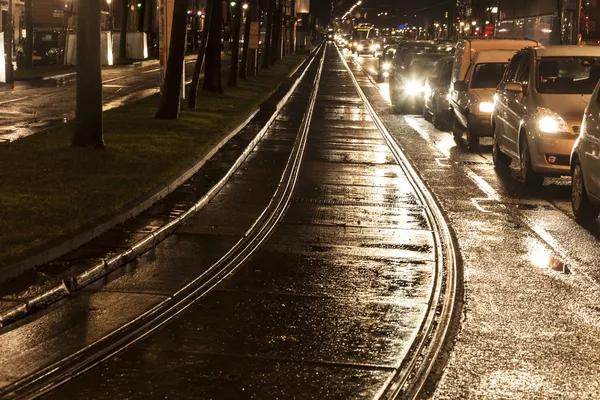 Υγρό άμαξα ράγες στο φως και δρόμους που αντανακλούν το φως — Φωτογραφία Αρχείου