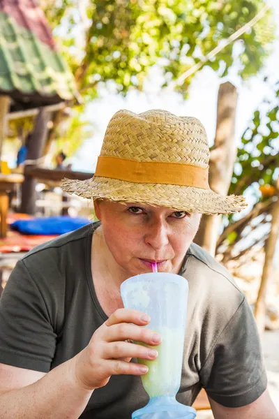Žena má ovocný nápoj v tropické restaurace — Stock fotografie