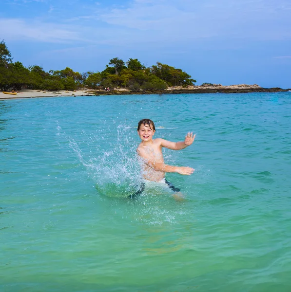 Beau garçon aime pulvériser avec sa main dans l 'oce tropicale — Photo