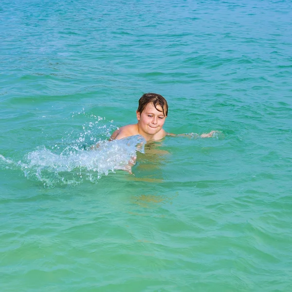 Chico guapo disfruta escupiendo con su mano en el oce tropical —  Fotos de Stock