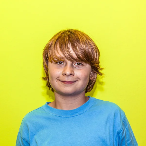 Счастливый улыбчивый мальчик с желтой стеной — стоковое фото