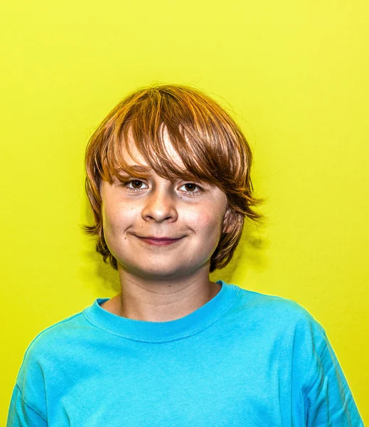 Szczęśliwy uśmiechnięty młody chłopiec z żółtą ścianą — Zdjęcie stockowe