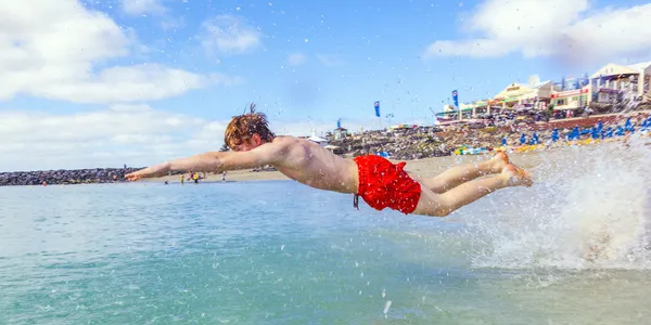 Chico tiene diversión en el mar claro — Stockfoto